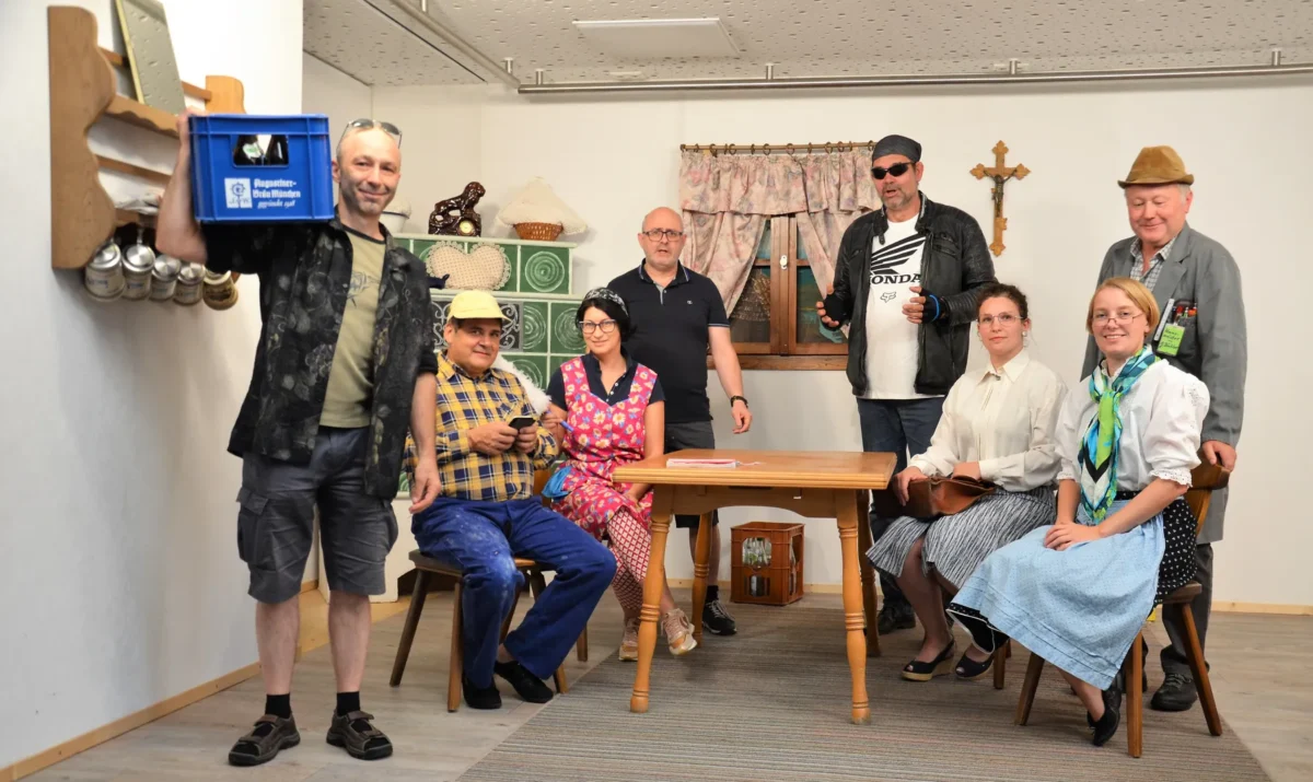 Ensemble von „Toni aus Paris“ in einer bayerischen Stube mit Kachelofen